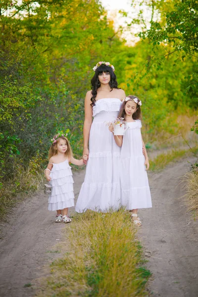 年轻的母亲与她的女儿在白色礼服的乐趣在夏日日落在河边 — 图库照片