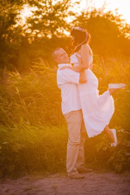 açık havada aşık çift. Gün batımı ile bir alanda yaz aylarında insanların Çarpıcı şehvetli portre