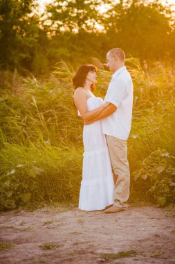 açık havada aşık çift. Gün batımı ile bir alanda yaz aylarında insanların Çarpıcı şehvetli portre