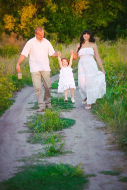 Mutlu ebeveynler ve gün batımında bir buğday tarlası ve nehir yaz açık havada eğlenmek küçük daugther