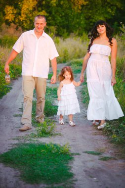 Mutlu ebeveynler ve gün batımında bir buğday tarlası ve nehir yaz açık havada eğlenmek küçük daugther