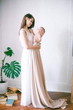 Aile, çocuk ve ebeveyn kavramı - küçük bebek evde ile mutlu gülümseyen genç anne