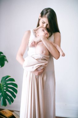 Aile, çocuk ve ebeveyn kavramı - küçük bebek evde ile mutlu gülümseyen genç anne