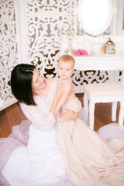 Parlak Boudoir yatak odasında kollarında bir bebek ile Genç Anne