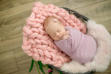 Güzel bahar Pembe lale ile süslenmiş bir hasır sepeti pembe battaniyede mükemmel yenidoğan bebek kız