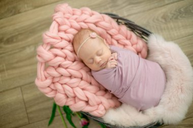 Güzel bahar Pembe lale ile süslenmiş bir hasır sepeti pembe battaniyede mükemmel yenidoğan bebek kız