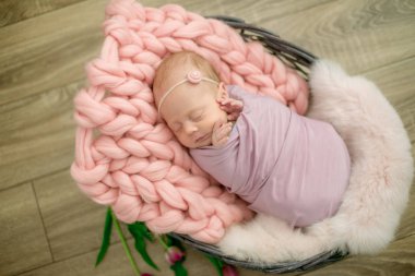 Güzel bahar Pembe lale ile süslenmiş bir hasır sepeti pembe battaniyede mükemmel yenidoğan bebek kız