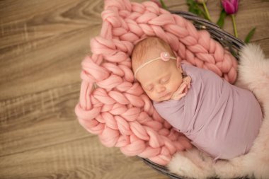 Güzel bahar Pembe lale ile süslenmiş bir hasır sepeti pembe battaniyede mükemmel yenidoğan bebek kız