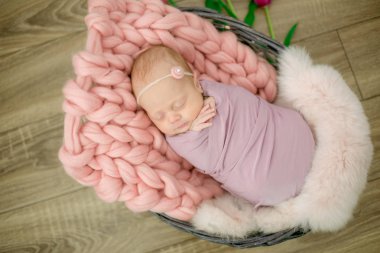 Güzel bahar Pembe lale ile süslenmiş bir hasır sepeti pembe battaniyede mükemmel yenidoğan bebek kız