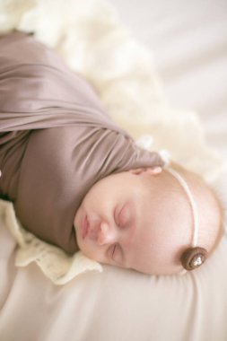 yatakta bir Wrap kahverengi battaniyede yeni doğmuş bebek uyku