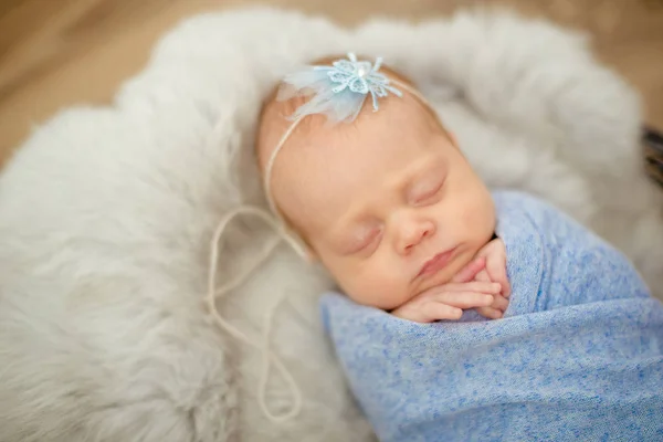 完美的新生女婴在蓝色毯子在柳条篮子装饰春天樱花的枝条 — 图库照片