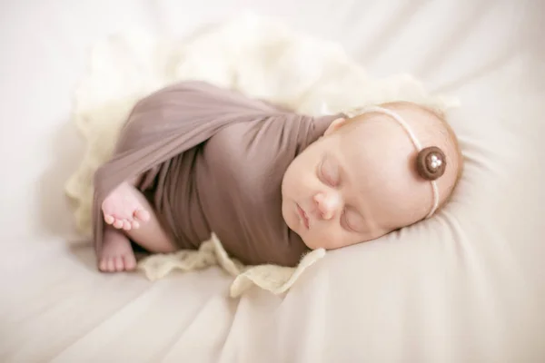睡在床上的棕色毯子里睡觉的新生儿 — 图库照片