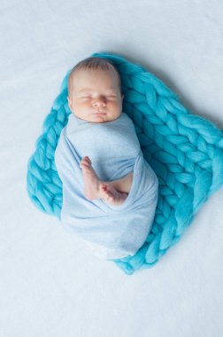 Evde yatakta mavi bir battaniye sevimli küçük bebek