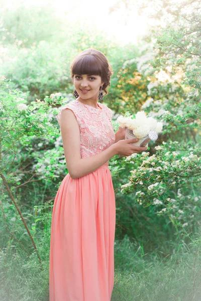 Młoda Atrakcyjna Dziewczyna Długiej Sukni Białymi Kwiatami Dłoniach Letnim Parku — Zdjęcie stockowe