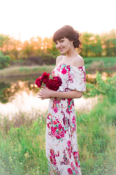 Menina Atraente Nova Vestido Longo Com Peônias Bordô Suas Mãos — Fotografia de Stock