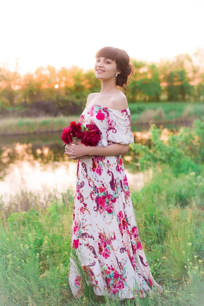 Menina Atraente Nova Vestido Longo Com Peônias Bordô Suas Mãos — Fotografia de Stock