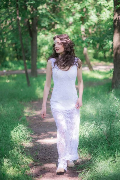 夏の公園で美しい髪型と長い白いドレスで魅力的な若い女の子 — ストック写真