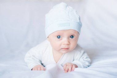  Yeni doğmuş çocuk yatakta diniyor. Aile sabahı evde. Evde mutlu bir şekilde gülümseyen karın zamanında yeni doğan çocuk
