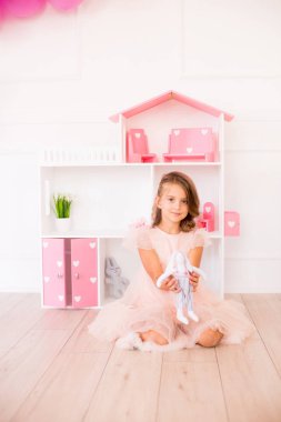 Evde güzel bir elbise sevimli mutlu kız bir dollhouse ve oyuncaklar ile oynar