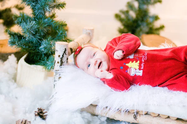 クリスマスの装飾で木製のベッドの上にクリスマスの衣装でかわいい新生児 — ストック写真