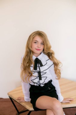 Okul moda giysileri uzun sarı kıvırcık saçlı sevimli kız. Vintage elit tarzda okul modası.