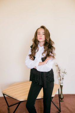 Okul moda giysileri uzun kıvırcık saçlı sevimli kız. Vintage elit tarzda okul modası.