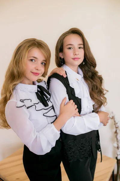 ファッショナブルな学校の服で長い巻き毛を持つ2人のかわいい女子高生 ヴィンテージエリートスタイルの学校ファッション — ストック写真