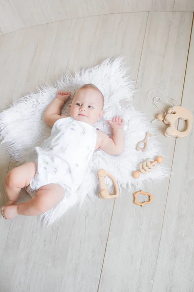 Lindo Bebê Recém Nascido Está Tapete Branco Joga Primeiros Brinquedos — Fotografia de Stock