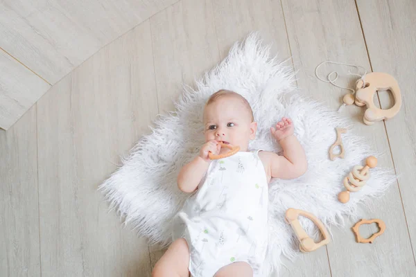 Ein Nettes Neugeborenes Liegt Auf Einem Weißen Teppich Und Spielt — Stockfoto