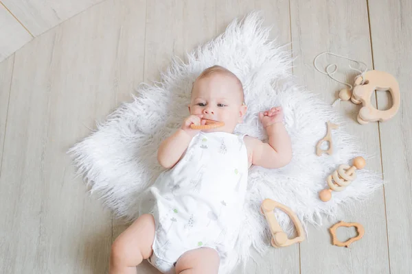 Lindo Bebê Recém Nascido Está Tapete Branco Joga Primeiros Brinquedos — Fotografia de Stock