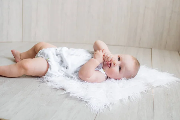 Lindo Bebê Recém Nascido Está Tapete Branco Joga Primeiros Brinquedos — Fotografia de Stock