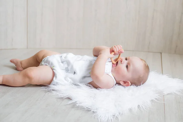 Lindo Bebê Recém Nascido Está Tapete Branco Joga Primeiros Brinquedos — Fotografia de Stock