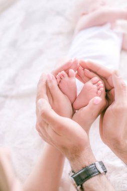 Küçük bebek ayakları ebeveynlerin elinde. Mutlu annelik