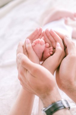 Küçük bebek ayakları ebeveynlerin elinde. Mutlu annelik