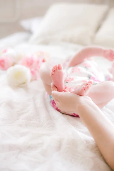 엄마의 침대에 집에서 신생아 귀여운 다리를 들고있다 행복한 — 스톡 사진