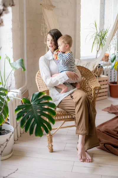 Genç bir anne evde yatak odasında küçük oğlu ile oynar. Mutlu annelik