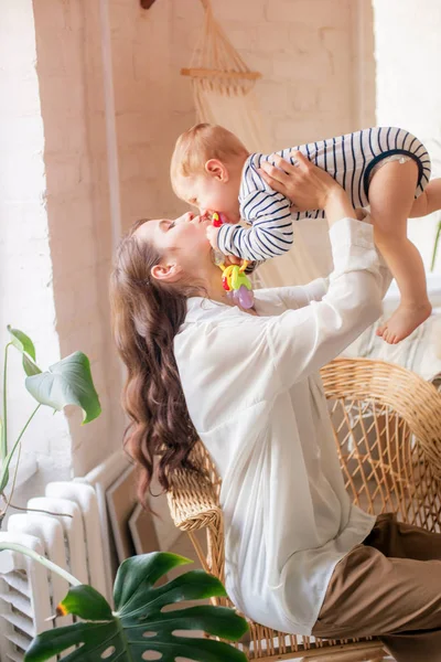 Genç bir anne evde yatak odasında küçük oğlu ile oynar. Mutlu annelik