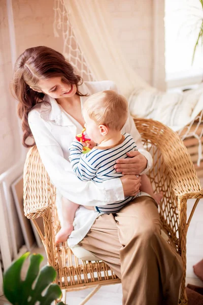 Genç bir anne evde yatak odasında küçük oğlu ile oynar. Mutlu annelik