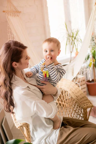 Genç bir anne evde yatak odasında küçük oğlu ile oynar. Mutlu annelik