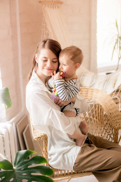 Genç bir anne evde yatak odasında küçük oğlu ile oynar. Mutlu annelik