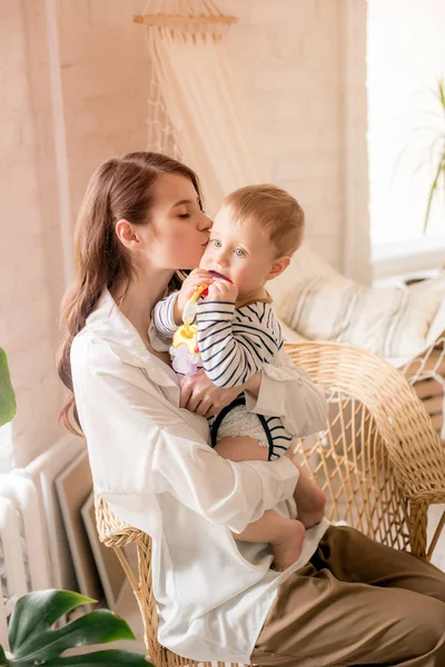 Genç bir anne evde yatak odasında küçük oğlu ile oynar. Mutlu annelik