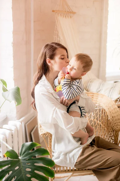 Genç bir anne evde yatak odasında küçük oğlu ile oynar. Mutlu annelik