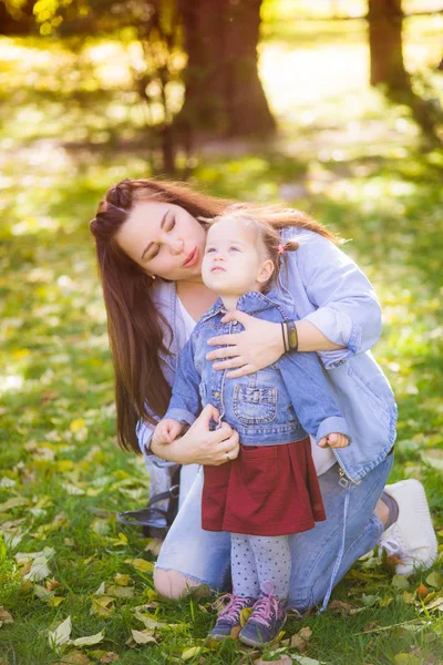 若い妊娠中の母親は 秋の公園で彼女の小さな娘と遊びます 幸せな母性幸せな健康な妊娠 — ストック写真