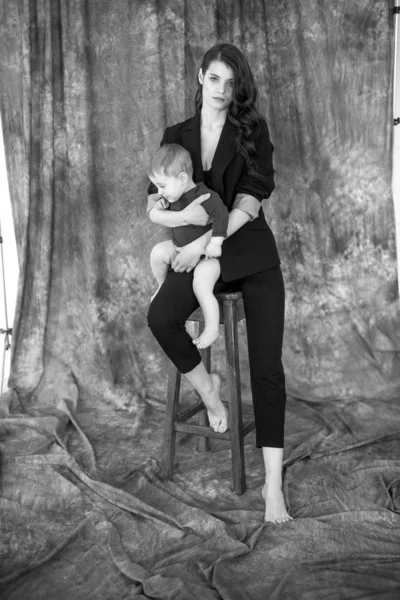 Молодая Красивая Мама Модном Брючном Костюме Держит Ребенка Руках Яркой — стоковое фото