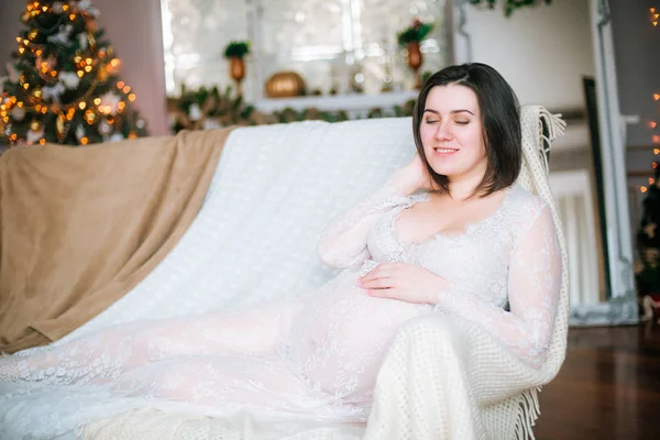 Joven Embarazada Con Pelo Oscuro Vestido Blanco Encaje Sofá Entorno — Foto de Stock