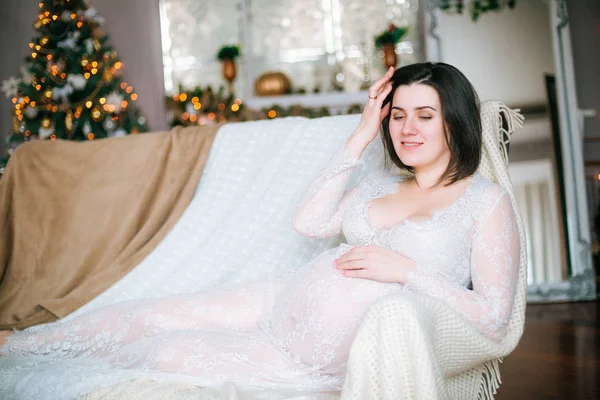 Menina Grávida Nova Com Cabelo Escuro Vestido Branco Renda Sofá — Fotografia de Stock