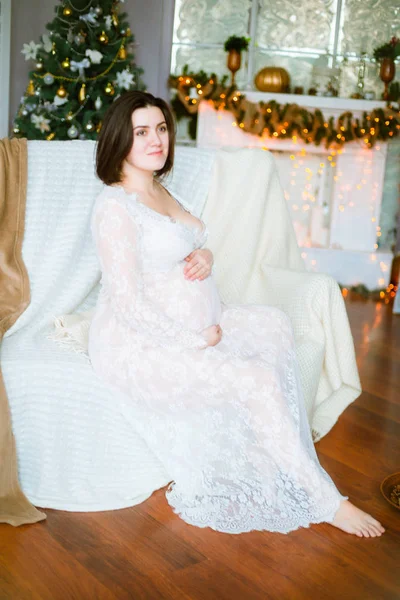 Młoda Dziewczyna Ciąży Ciemnymi Włosami Koronką Białą Sukienkę Kanapie Ustawieniu — Zdjęcie stockowe
