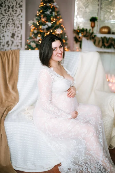 Joven Embarazada Con Pelo Oscuro Vestido Blanco Encaje Sofá Entorno —  Fotos de Stock