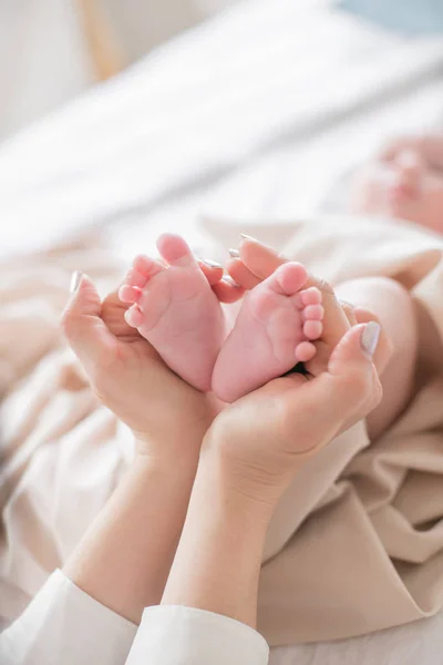 Mom Hands Holding Little Cute Legs Newborn Baby Home White — Stock Photo, Image