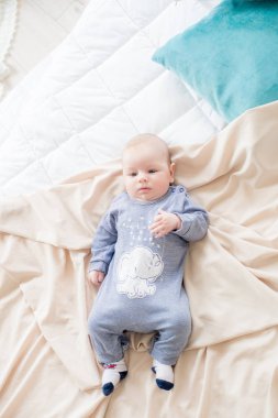 Küçük sevimli bebek yatakta evde yatıyor. Mutlu çocukluk